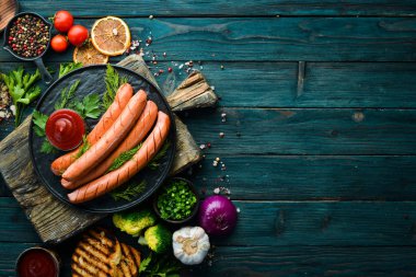 Siyah tabakta kaynamış sosis ve ketçap. Üst Manzara. Metnin için boş yer.