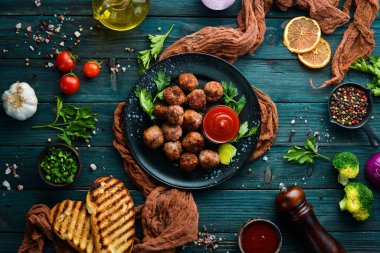 Siyah tabakta ketçaplı fırında biftek köftesi. Üst Manzara. Metnin için boş yer.