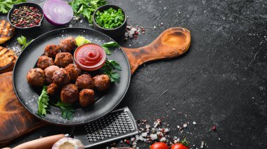 Siyah tabakta ketçaplı fırında biftek köftesi. Üst Manzara. Metnin için boş yer.