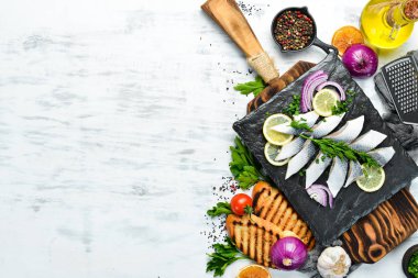 Siyah taş bir tahtanın üzerinde soğan ve limonla tuzlanmış ringa balığı. Üst Manzara. Metnin için boş yer.