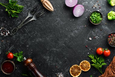 Siyah yemek geçmişi. Siyah arka planda sebzeler ve baharatlar. Üst Manzara. Metnin için boş yer.