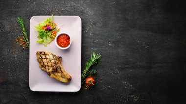 Kemiğin üzerinde salata ve sosla domuz eti. Üst Manzara. Metnin için boş yer.