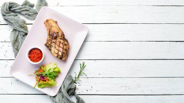 Kemiğin üzerinde salata ve sosla domuz eti. Üst Manzara. Metnin için boş yer.