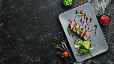 Beef steak with salad and sauce. Top view. Free space for your text.