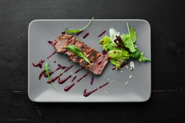 Beef steak with salad and sauce. Top view. Free space for your text.