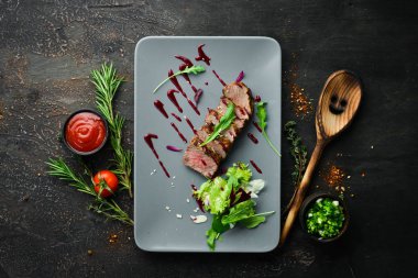 Beef steak with salad and sauce. Top view. Free space for your text.