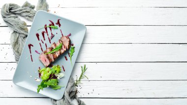 Beef steak with salad and sauce. Top view. Free space for your text.