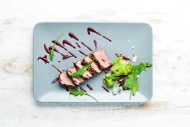 Beef steak with salad and sauce. Top view. Free space for your text.