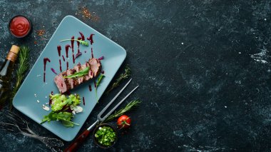 Beef steak with salad and sauce. Top view. Free space for your text.