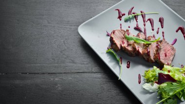 Beef steak with salad and sauce. Top view. Free space for your text.