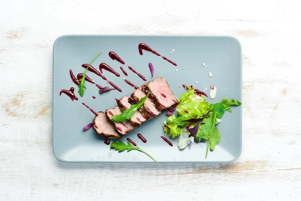 Beef steak with salad and sauce. Top view. Free space for your text.