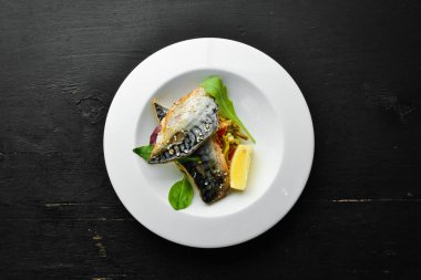 Baked mackerel fillet with vegetables. Top view. Free space for your text.