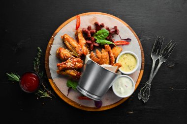 Snacks to beer on the board. Chicken wings, nuggets, sausages. Top view. Free space for your text.