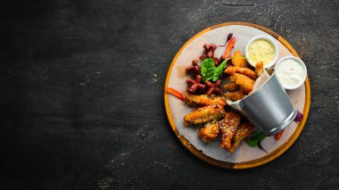 Snacks to beer on the board. Chicken wings, nuggets, sausages. Top view. Free space for your text.