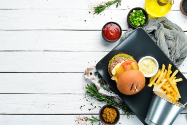 Burger with meat, cheese and french fries. Top view. Free space for your text.