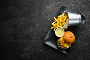 Burger with meat, cheese and french fries. Top view. Free space for your text.