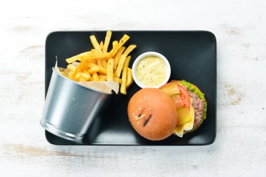 Burger with meat, cheese and french fries. Top view. Free space for your text.