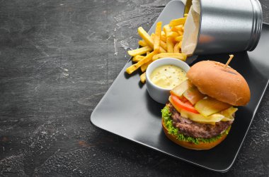 Burger with meat, cheese and french fries. Top view. Free space for your text.