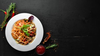 Pasta with tomatoes and vegetables. Carbonara. Italian cuisine. Top view. Free space for your text.