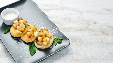 Cheese pancakes with sour cream. Dessert. Top view. Free space for your text.