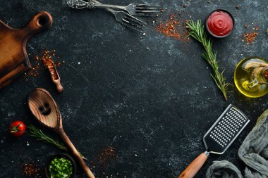 Dark cooking banner. Vegetables and spices on the kitchen table. Top view. Free space for your text.