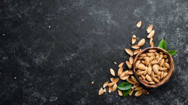 Walnut almonds in the shell. Nuts on a black stone background. Top view. Free space for your text.