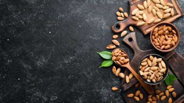 Nuts - protein. Almonds on black stone background. Top view. Free space for your text.
