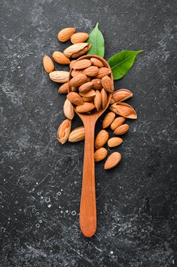 Almond nut in a wooden spoon. Top view. Free space for your text.