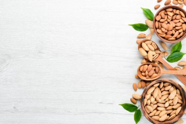 Kaçık. Bademler beyaz tahta bir masada. Üst Manzara. Metnin için boş yer.
