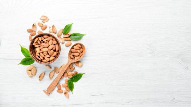 Kaçık. Bademler beyaz tahta bir masada. Üst Manzara. Metnin için boş yer.