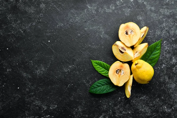 Quince. Quince fruits on a black stone background. Top view. Free space for text.