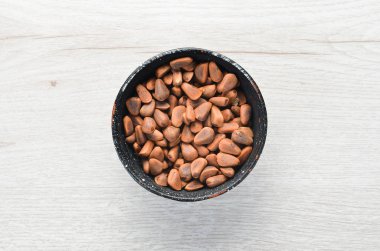 Kabuktaki sedir fıstığı, bir kase içinde. Metnin için boş yer. Üst görünüm.