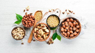 Beyaz ahşap arka planda fındık çeşitleri. Metnin için boş yer. Üst görünüm.