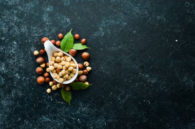 Siyah taşlı arka planda bir kasede fındık. Çatlak. Metnin için boş yer. Üst görünüm.