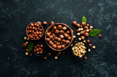 Siyah taşlı arka planda bir kasede fındık. Çatlak. Metnin için boş yer. Üst görünüm.