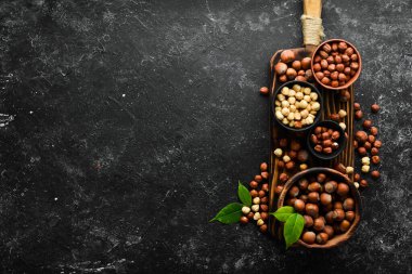 Siyah taşlı arka planda bir kasede fındık. Çatlak. Metnin için boş yer. Üst görünüm.