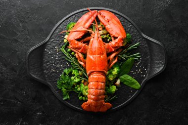 Siyah taş tabakta sebzeli haşlanmış ıstakoz. Deniz ürünleri. Üst Manzara. Metnin için boş yer.