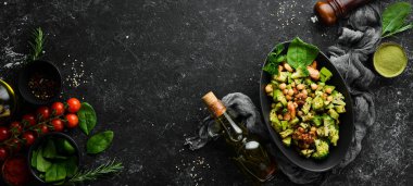 Sağlıklı avokado salatası, nohut, brokoli ve tavuk, siyah taş tabakta. Üst Manzara. Metnin için boş yer.