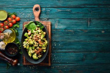 Sağlıklı avokado salatası, nohut, brokoli ve tavuk, siyah taş tabakta. Üst Manzara. Metnin için boş yer.