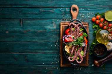 Siyah taş tabakta ızgara sebzeli büyük ahtapot haşladım. Deniz ürünleri. Üst Manzara. Metnin için boş yer.