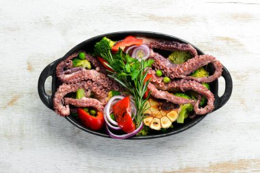 Siyah taş tabakta ızgara sebzeli büyük ahtapot haşladım. Deniz ürünleri. Üst Manzara. Metnin için boş yer.