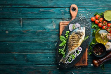 Siyah taş tabakta sebzeli fırında Dorado balığı. Üst Manzara. Metnin için boş yer.