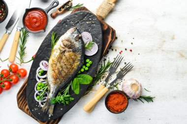Siyah taş tabakta sebzeli fırında Dorado balığı. Üst Manzara. Metnin için boş yer.