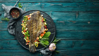 Kara Taş bir tabakta sebzeli fırında balık. Deniz ürünleri. Üst Manzara. Metnin için boş yer.