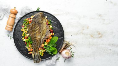 Kara Taş bir tabakta sebzeli fırında balık. Deniz ürünleri. Üst Manzara. Metnin için boş yer.