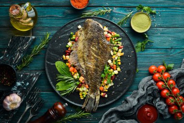 Kara Taş bir tabakta sebzeli fırında balık. Deniz ürünleri. Üst Manzara. Metnin için boş yer.