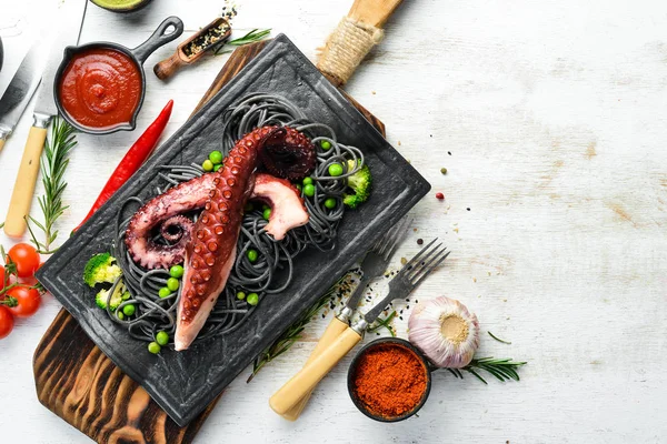 Zwarte Pasta Met Octopus Tentakels Een Zwarte Stenen Plaat Zeevruchten — Stockfoto