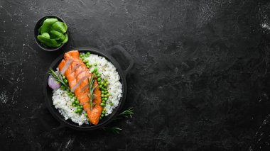 Siyah taş tabakta pilav ve sebzeli fırında tavuk filetosu. Diyet yemek. Üst Manzara. Metnin için boş yer.