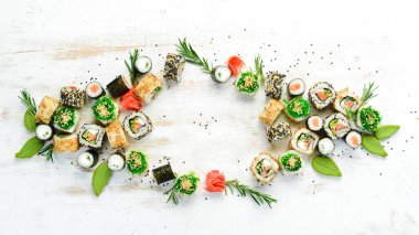Beyaz ahşap arka planda lezzetli suşi ve maki ruloları. Japon yemeği. Üst Manzara. Metnin için boş yer.