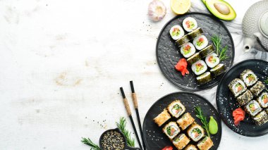 Suşi ruloları ve beyaz ahşap arka planda çay ile çaydanlık. Harika Japon yemekleri..